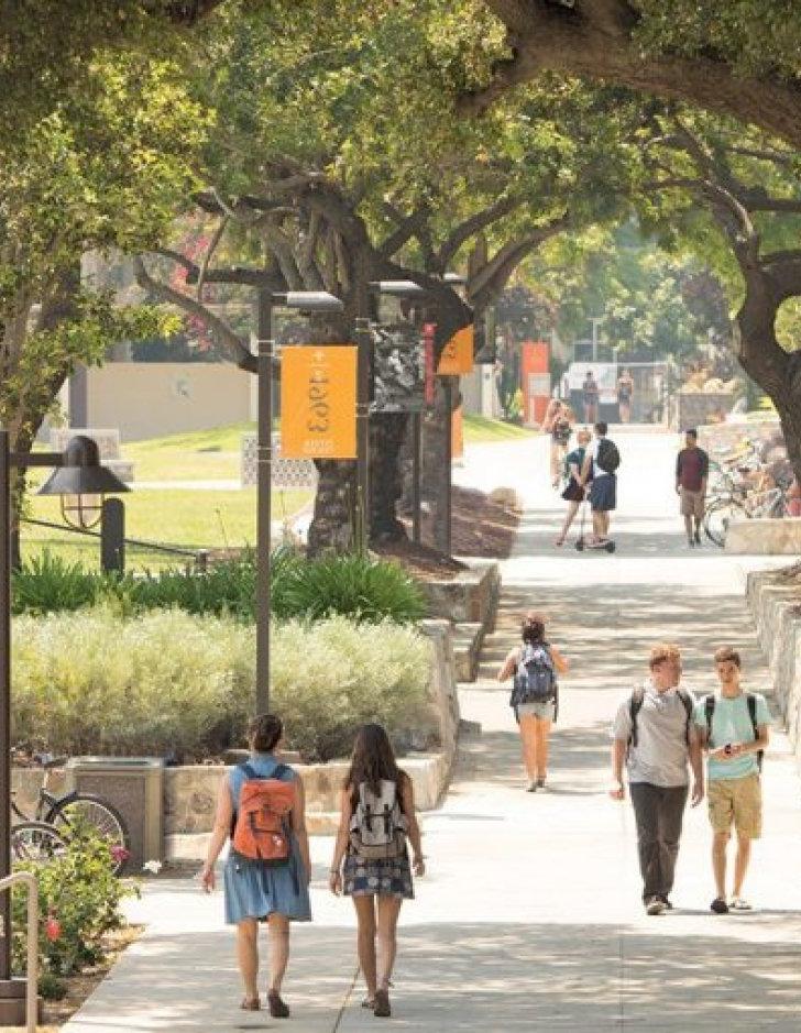 Pitzer College gates with students walking